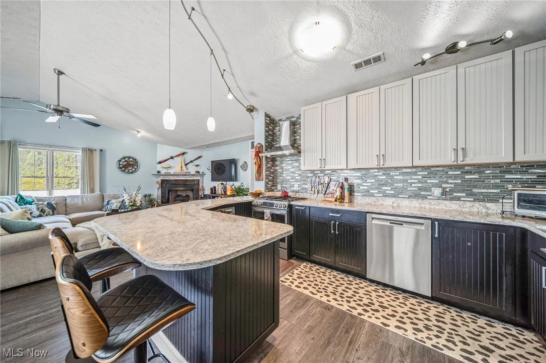Showstopper kitchen has a stainless steel hood, gorgeous Cambria countertops, custom cabinetry to the ceiling, beautiful backsplash & is open to the rest of the entertaining area!