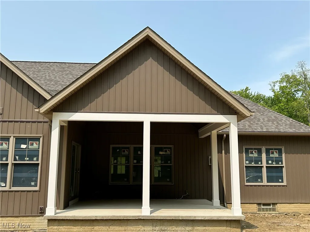Property entrance with roof with shingles and covered porch