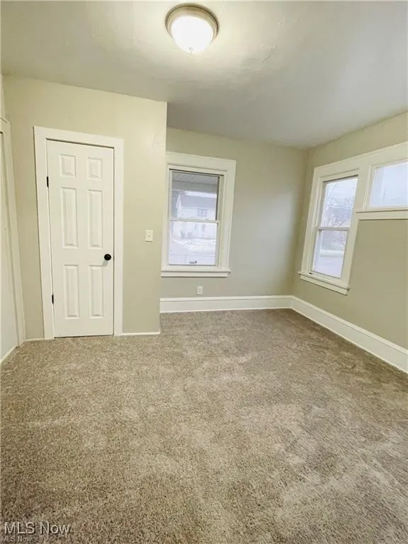 Empty room with baseboards and carpet