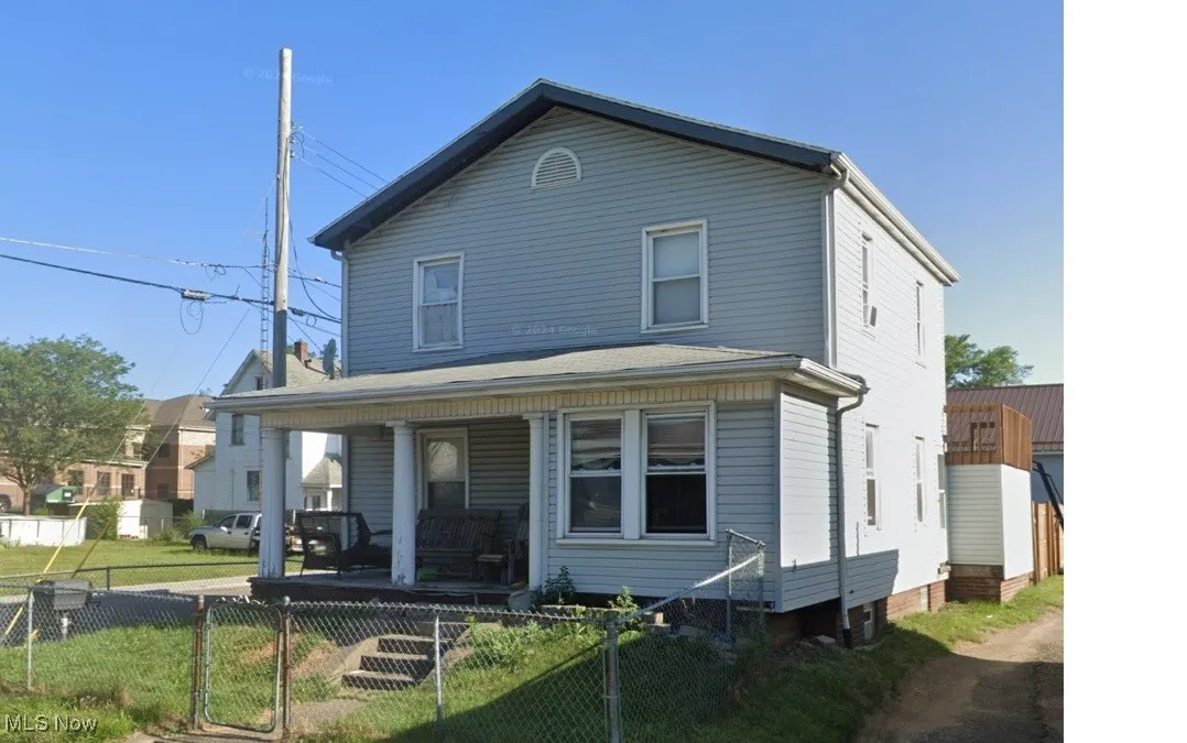 View of front of property featuring covered porch, a fenced front yard, and a gate