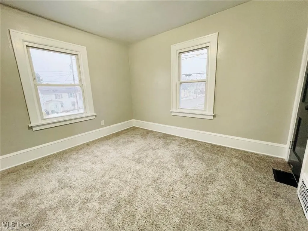 Spare room with healthy amount of natural light, carpet flooring, and baseboards