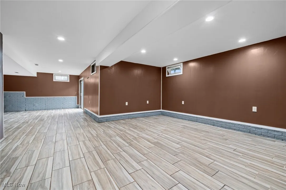 Below grade area featuring light wood-style flooring, healthy amount of natural light, baseboards, and recessed lighting