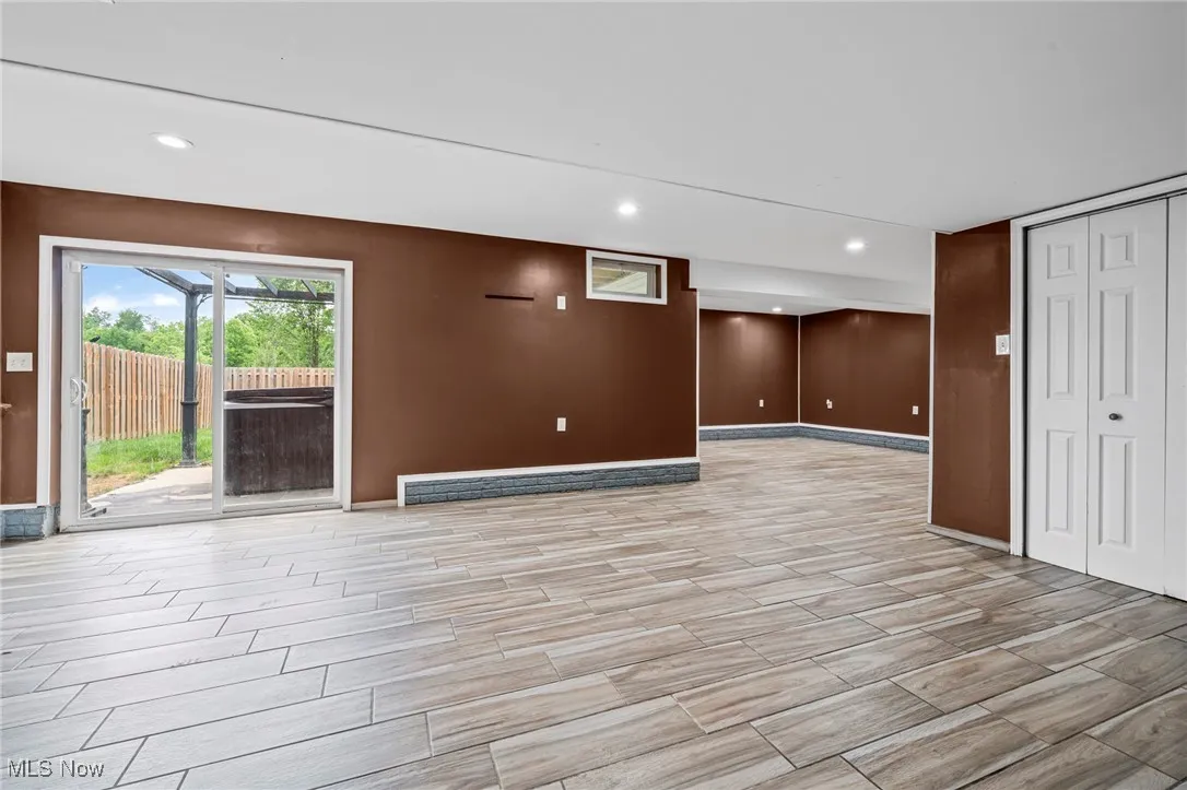 Unfurnished living room featuring baseboards, recessed lighting, and light wood-style flooring