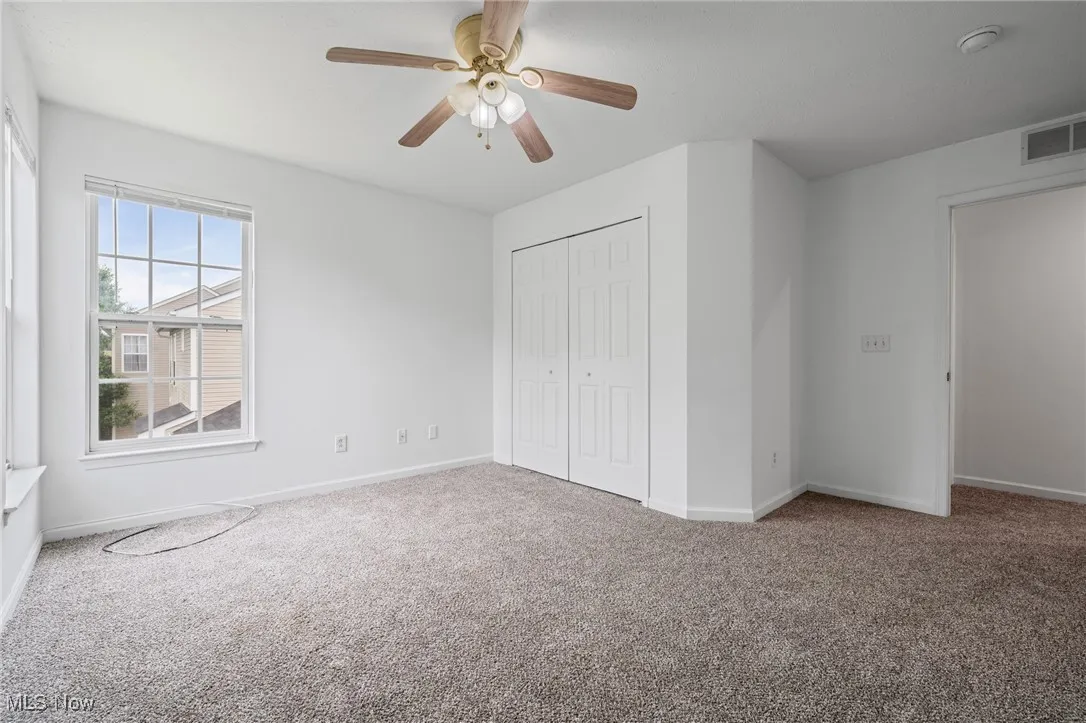 Unfurnished bedroom featuring carpet, baseboards, a closet, and ceiling fan