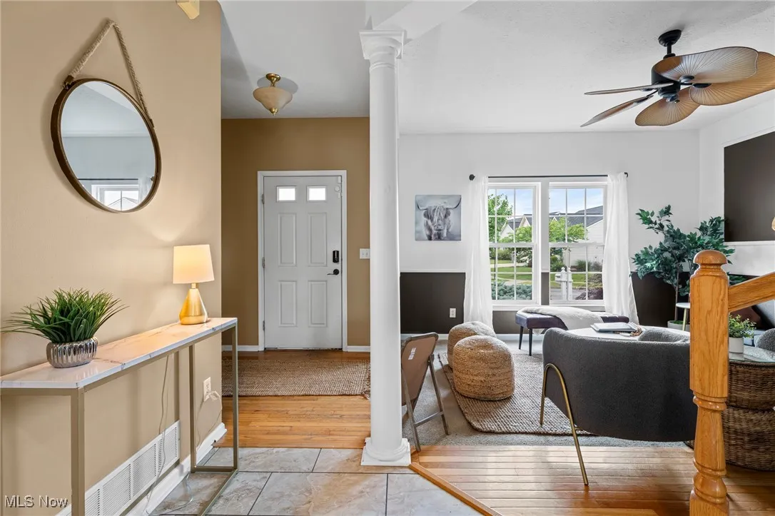 Foyer with ceiling fan and ornate columns