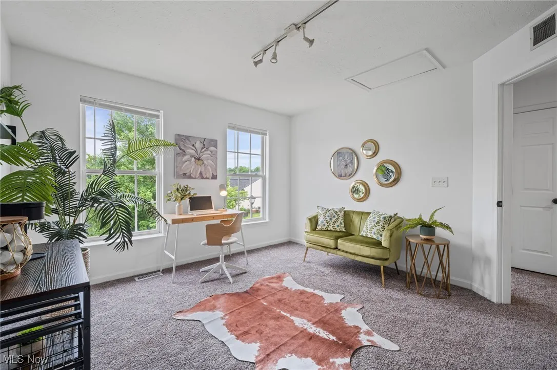 Carpeted office with attic access, track lighting, and baseboards