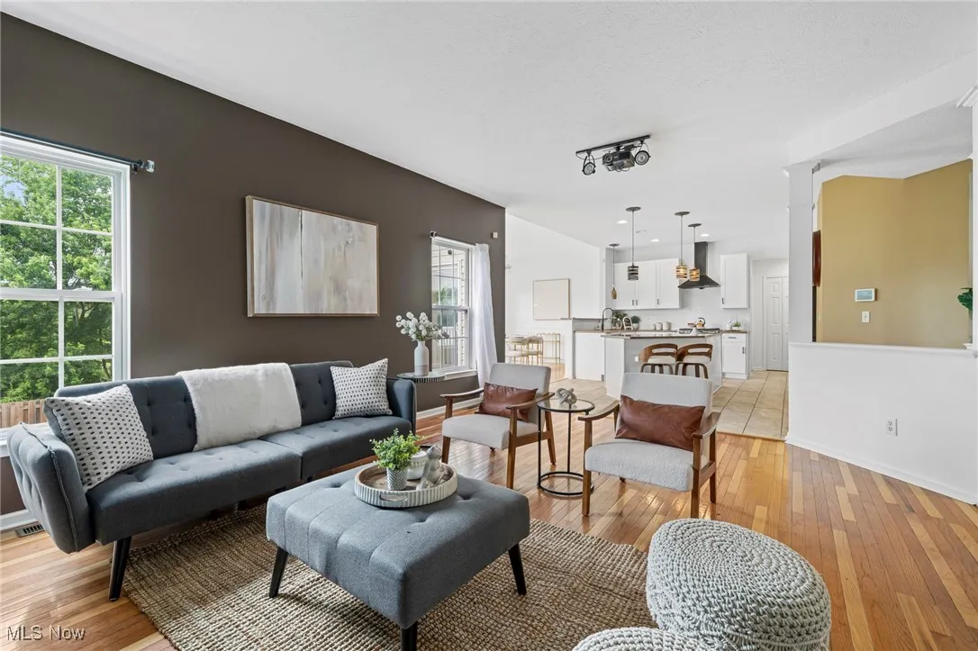 Living room with healthy amount of natural light, light wood-type flooring, and baseboards