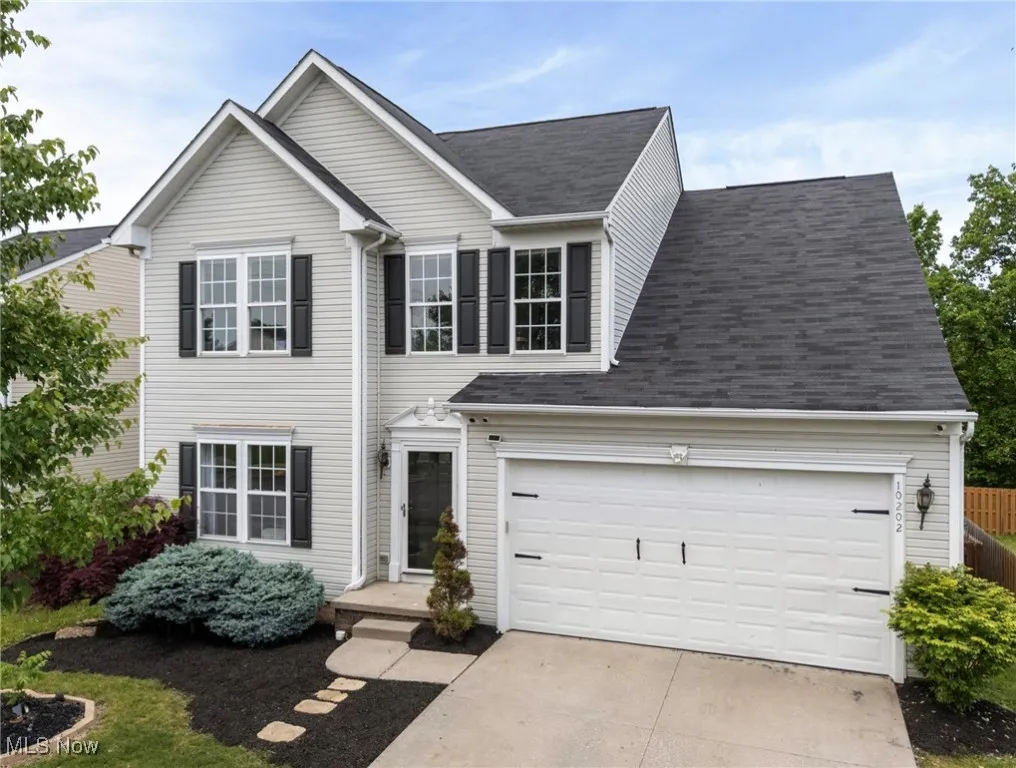 Traditional home with driveway and a shingled roof