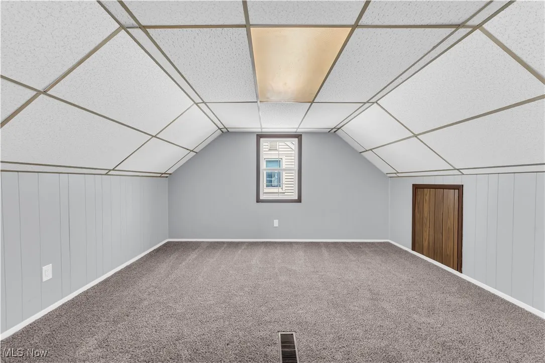 Bonus room with carpet flooring, baseboards, and lofted ceiling