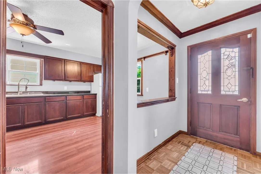 Entryway with a ceiling fan, baseboards, a textured ceiling, and arched walkways