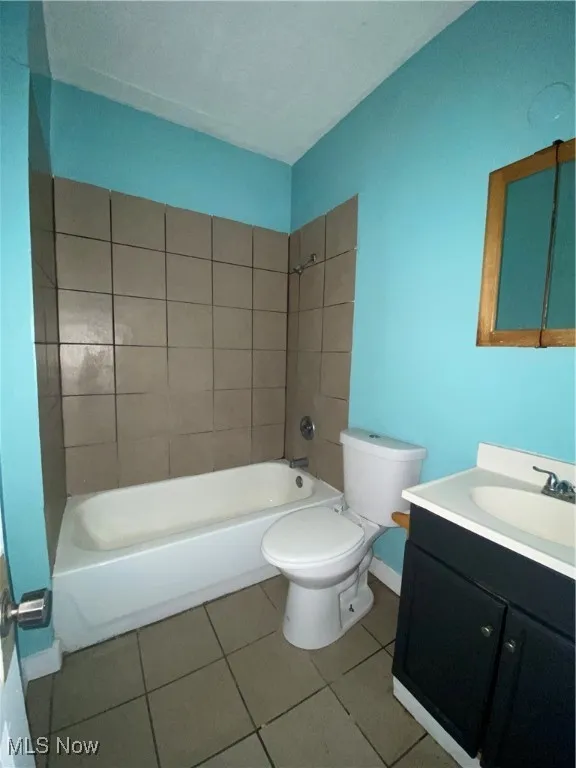 Full bath featuring toilet, vanity, tile patterned flooring, shower / washtub combination, and baseboards