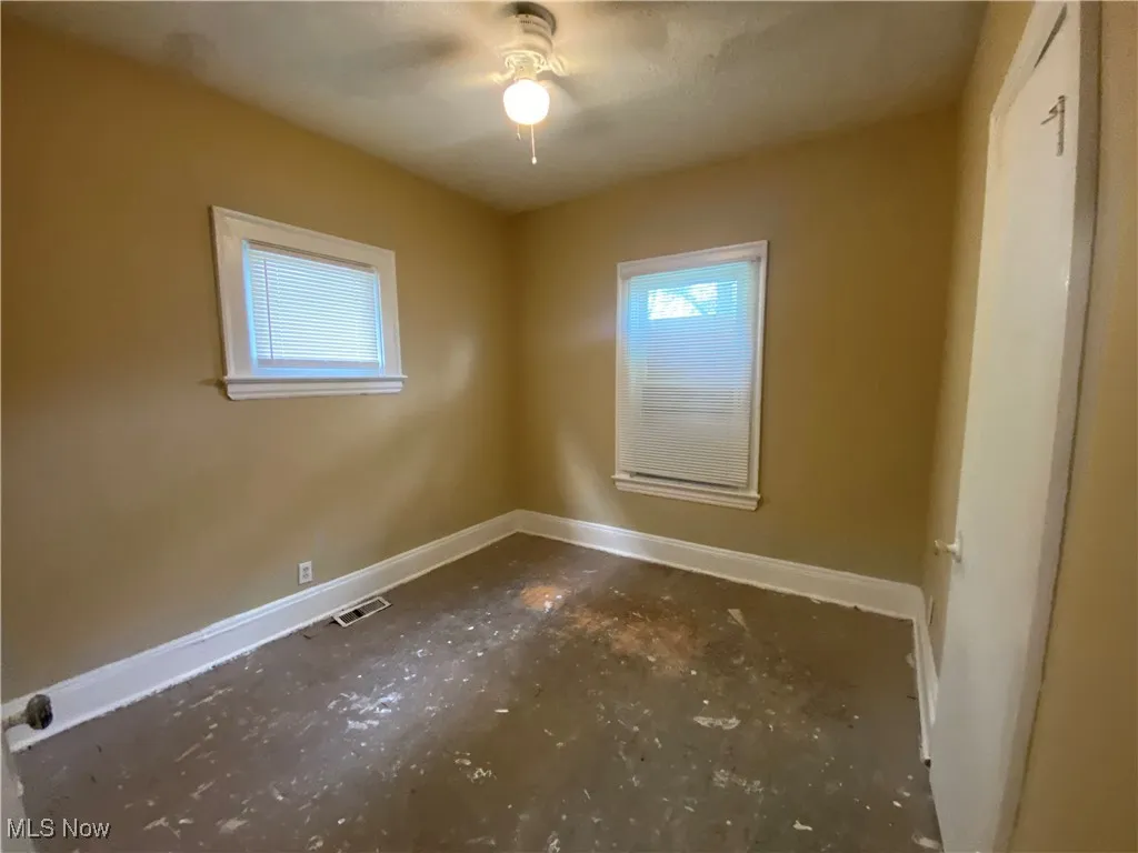 Empty room with baseboards and unfinished concrete floors