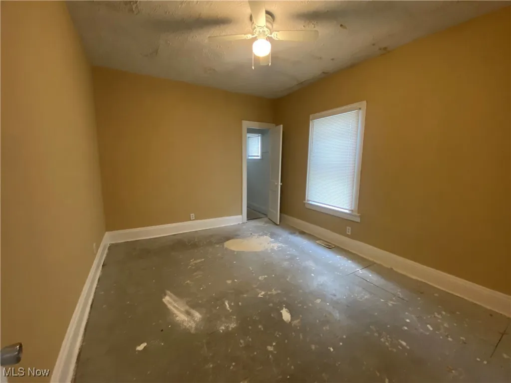 Spare room with a ceiling fan and baseboards