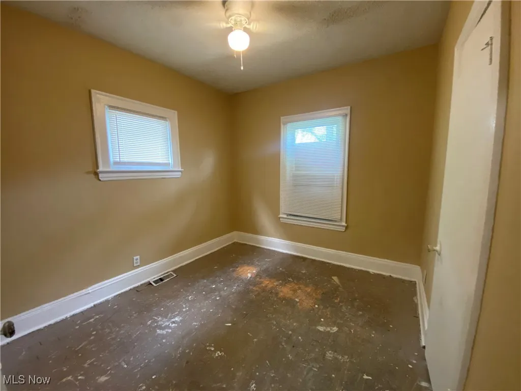 Unfurnished room with baseboards and ceiling fan