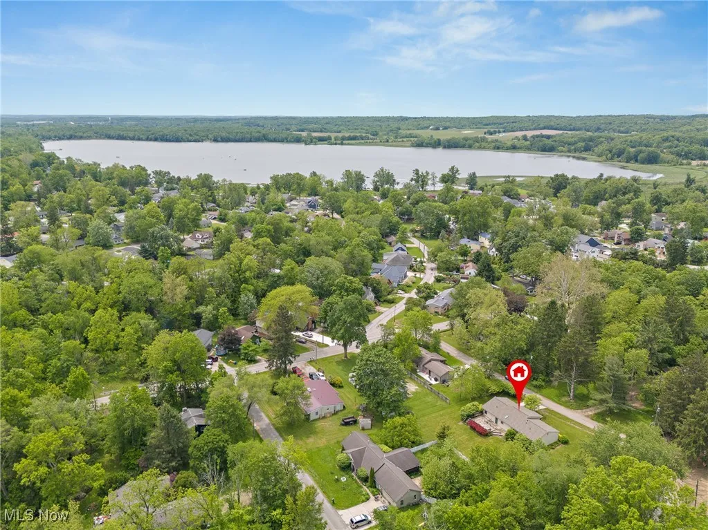 Aerial view of a nearby body of water and a heavily wooded area picture taken before patio removal