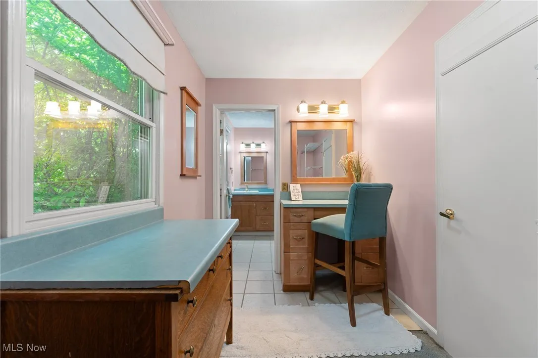 Bathroom featuring vanity, tile patterned floors, and baseboards