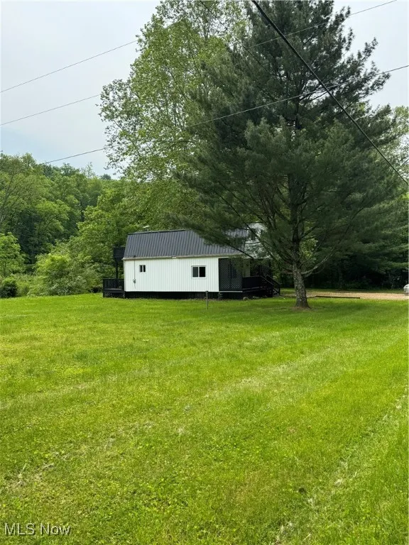 View of green lawn featuring a view of trees