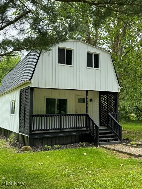View of front of house featuring a porch, a front yard, and board and batten siding