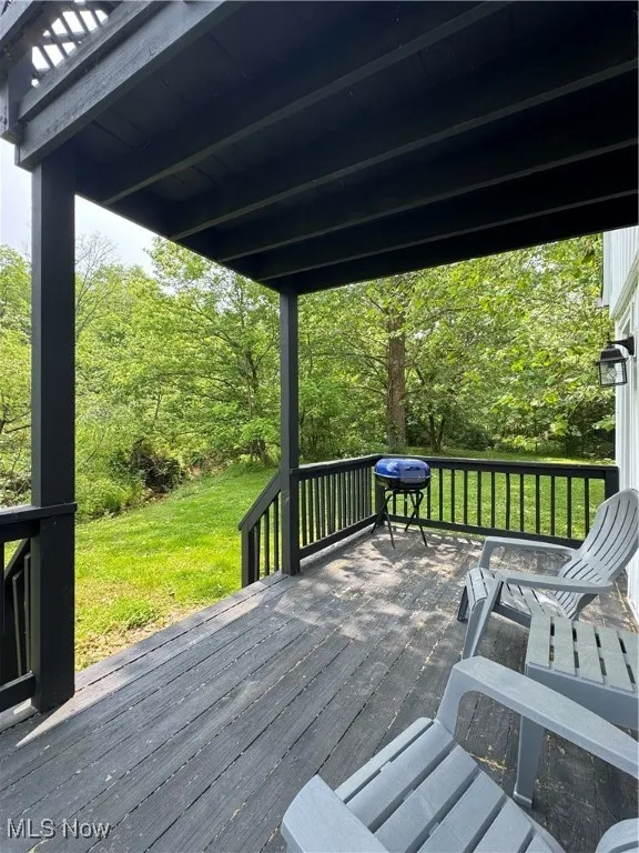 Wooden deck featuring a yard and a grill