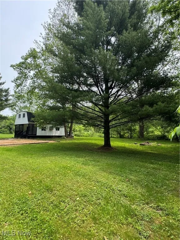 View of green lawn with a barn and an outbuilding