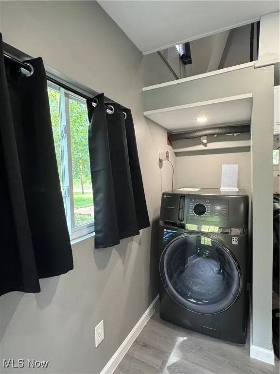 Laundry room featuring washer / clothes dryer, wood finished floors, and baseboards