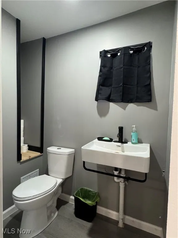 Half bathroom featuring toilet and baseboards