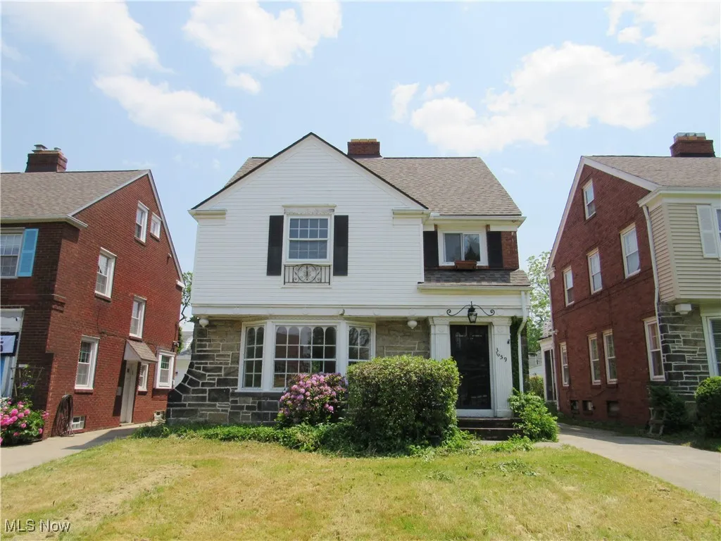 View of front of house featuring a front yard and stone siding