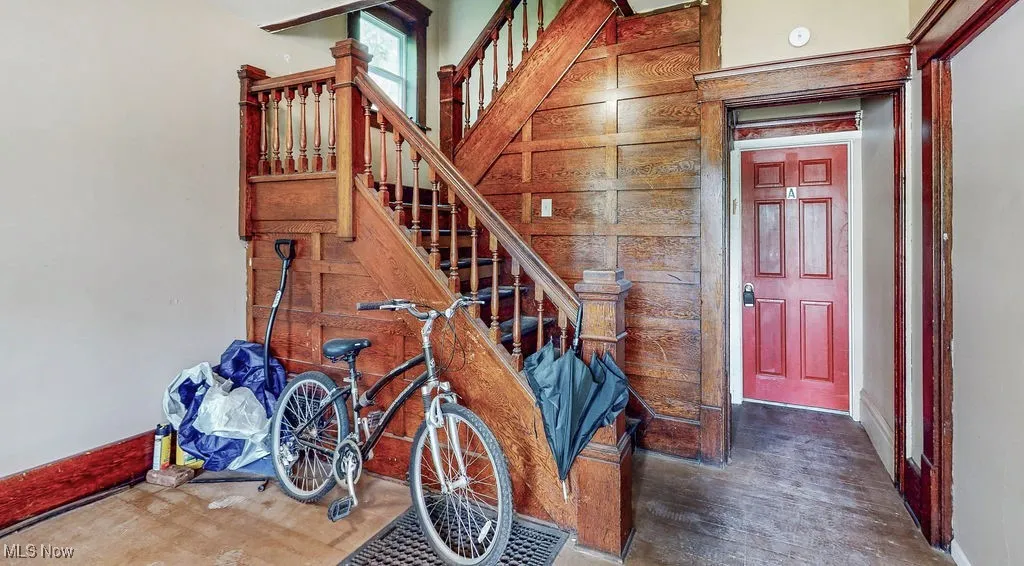 Common area stairway featuring wood finished floors and baseboards