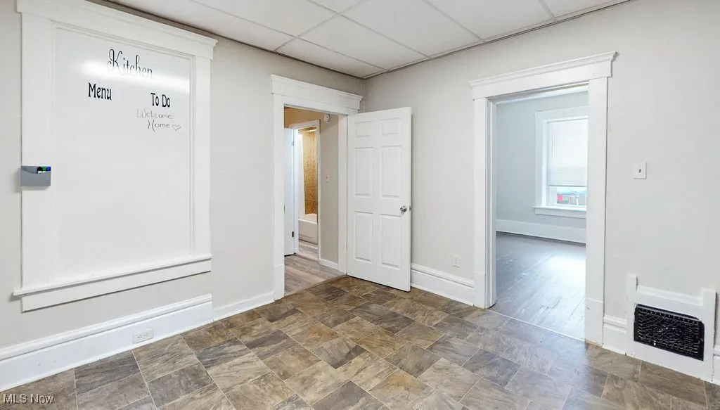  Eat-in kitchen featuring baseboards and a paneled ceiling