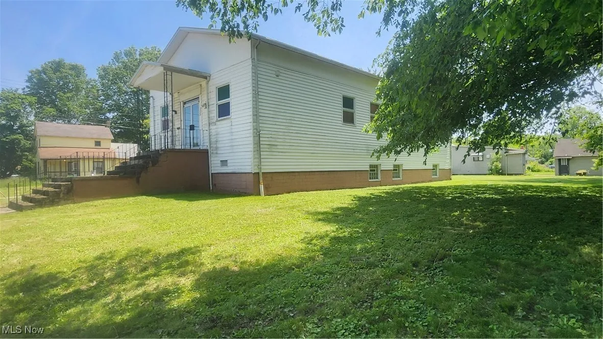 View of side of property featuring a yard