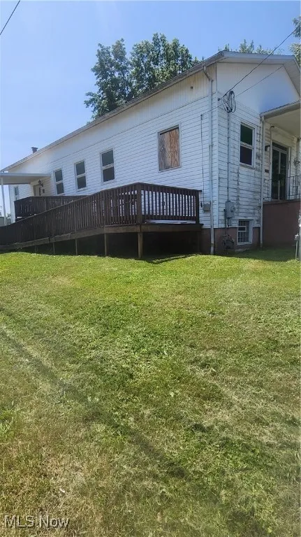 Rear view of property with a yard and a wooden deck