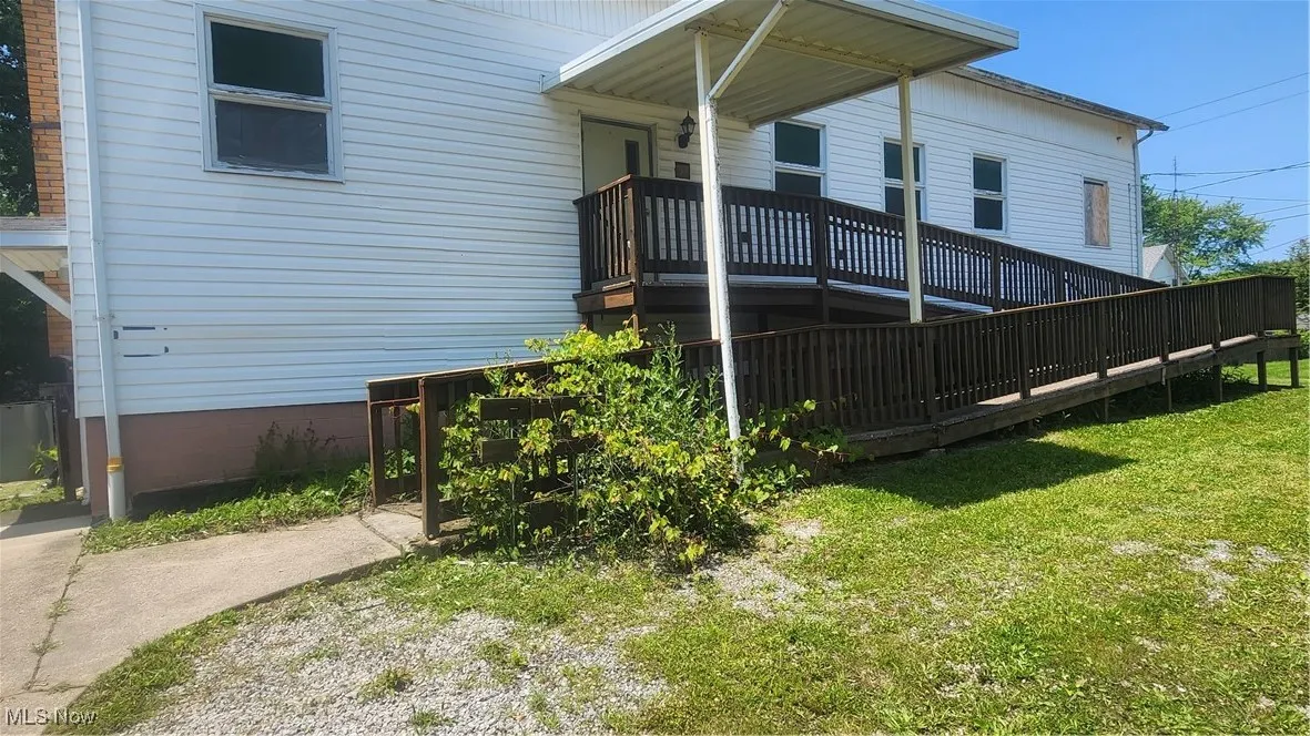 View of front of home with a front lawn and a deck