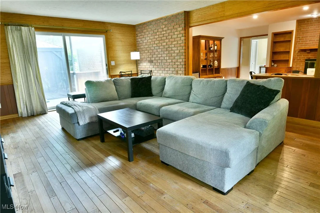Living area with light wood finished floors and wooden walls