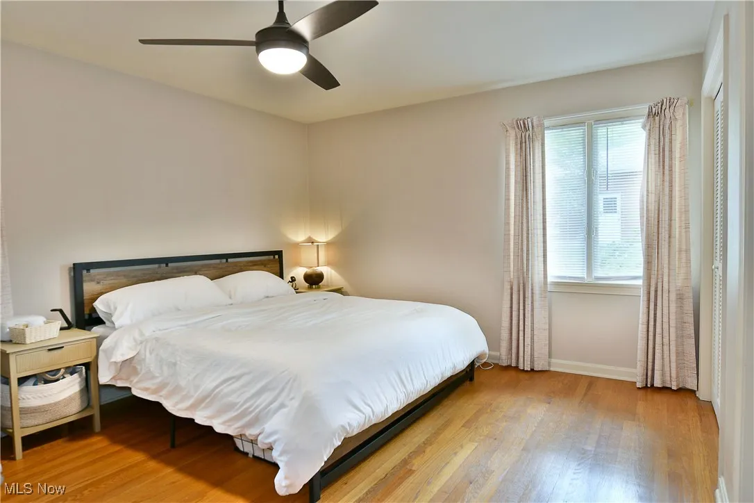 Bedroom with baseboards, wood finished floors, and a ceiling fan