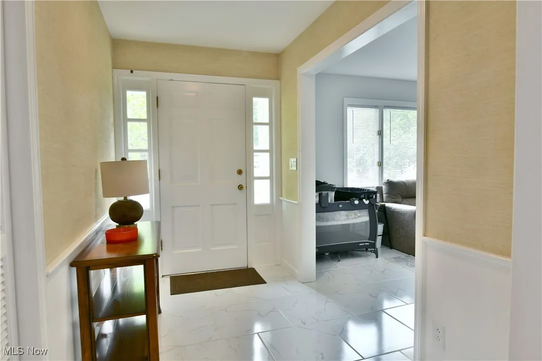 Foyer with marble look tile flooring and healthy amount of natural light