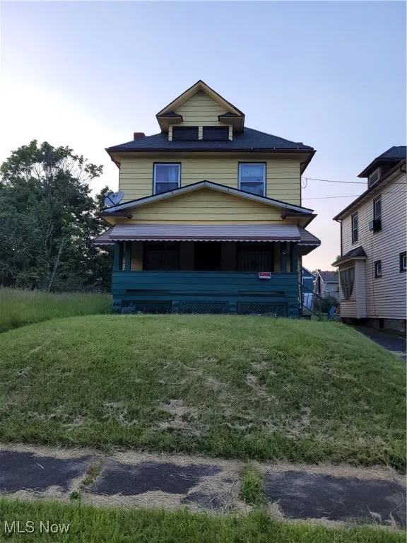 American foursquare style home featuring a yard
