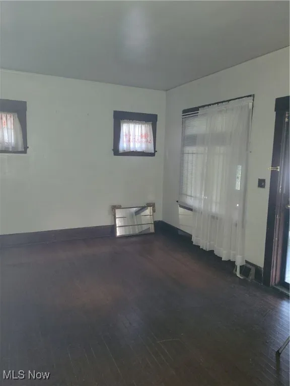 Living room featuring wood finished floors, plenty of natural light, and baseboards