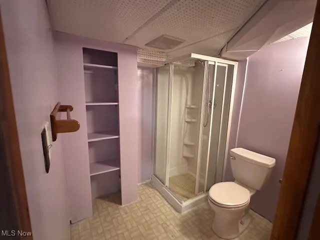 Bathroom with a shower stall and toilet basement