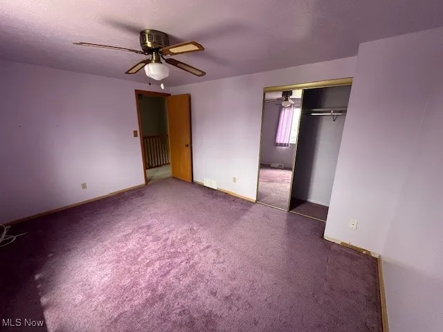 Bedroom 3 with a closet, carpet flooring, ceiling fan, radiator heating unit, and baseboards