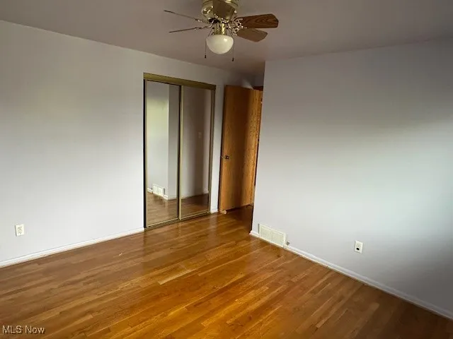 Bedroom 2 with wood finished floors, ceiling fan, and baseboards