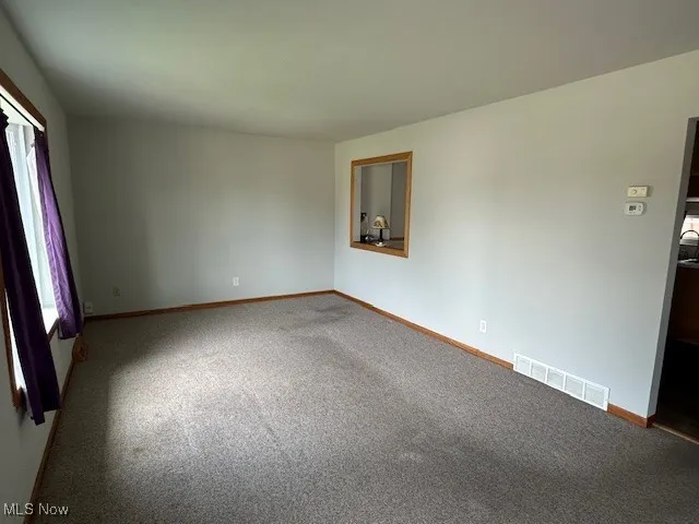 Empty room with carpet and baseboards