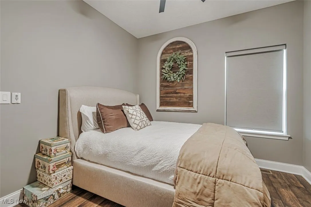 Bedroom featuring wood finished floors, baseboards, and a ceiling fan