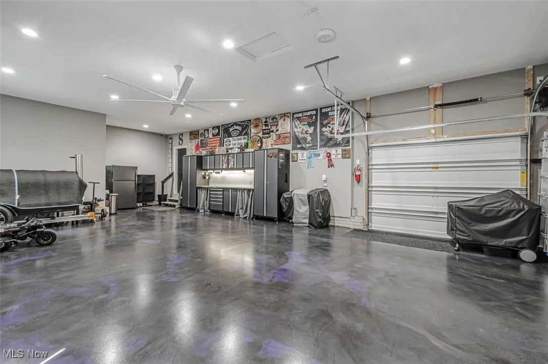 Garage featuring recessed lighting, ceiling fan, and freestanding refrigerator