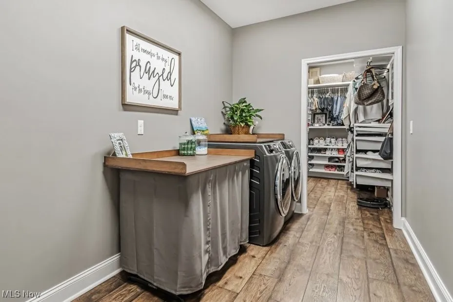 Washroom featuring independent washer and dryer, hardwood / wood-style floors, and baseboards