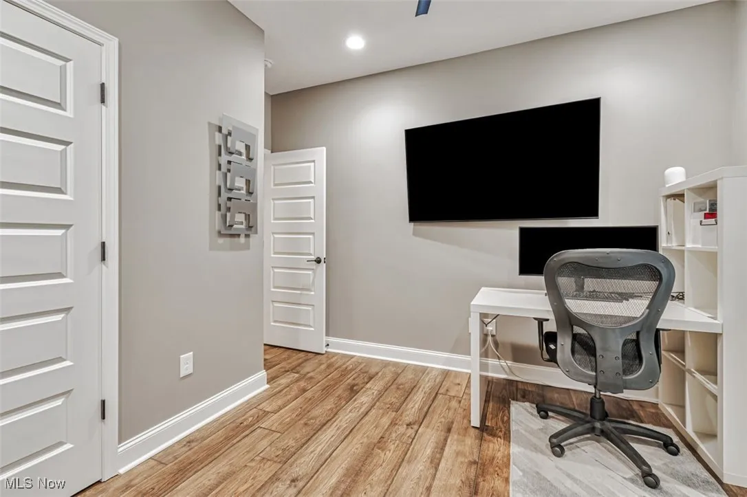 Office space with light wood-style floors, baseboards, and recessed lighting