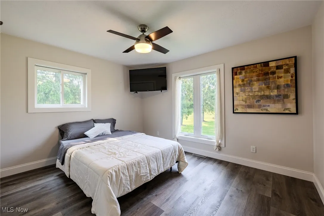 Spare Bedroom with baseboards, dark wood-style flooring, and ceiling fan