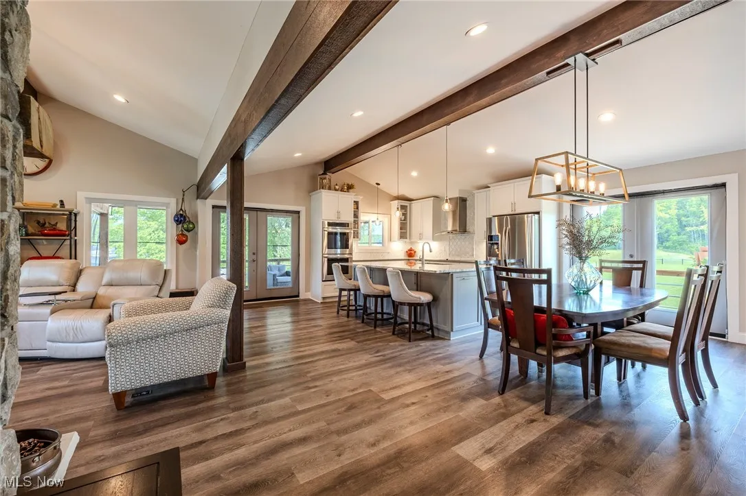 Dining space featuring healthy amount of natural light, dark wood-style flooring, a chandelier, and recessed lighting