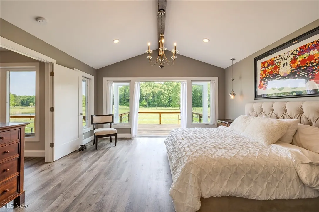 Owner'sBedroom featuring light wood-style flooring, access to outside, baseboards, recessed lighting, and a chandelier