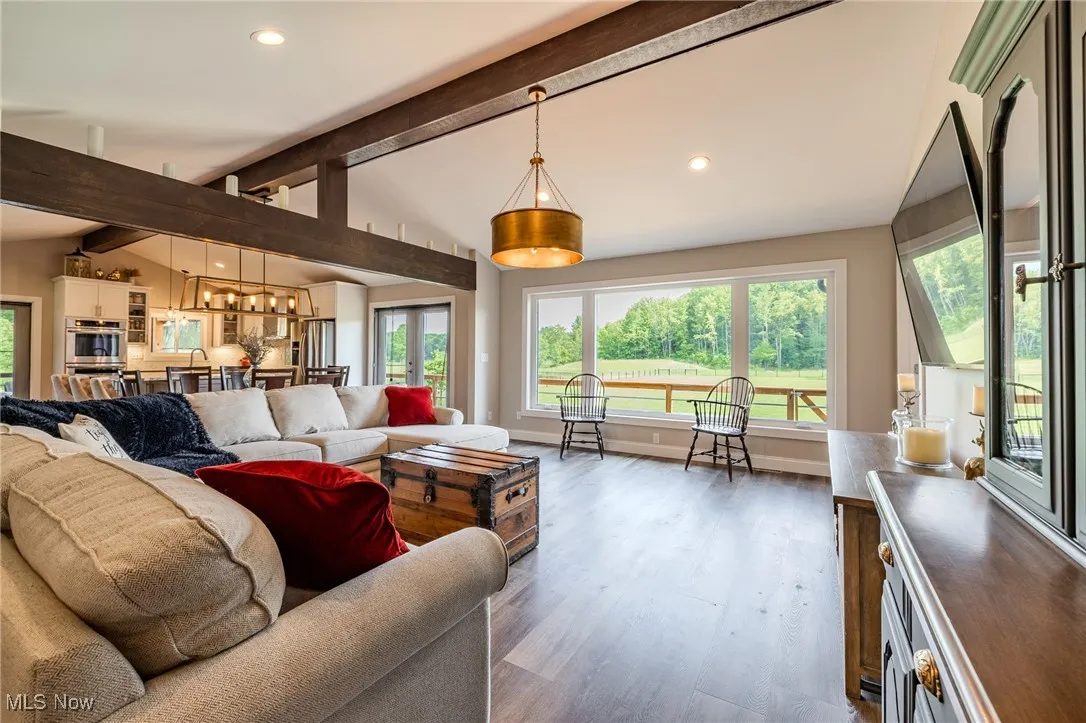Living area with wood finished floors, recessed lighting, healthy amount of natural light, and a chandelier