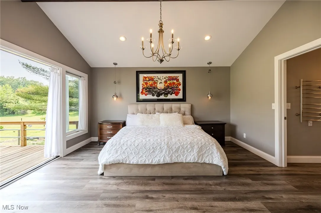 Bedroom with vaulted ceiling, a chandelier, wood finished floors, radiator heating unit, and recessed lighting